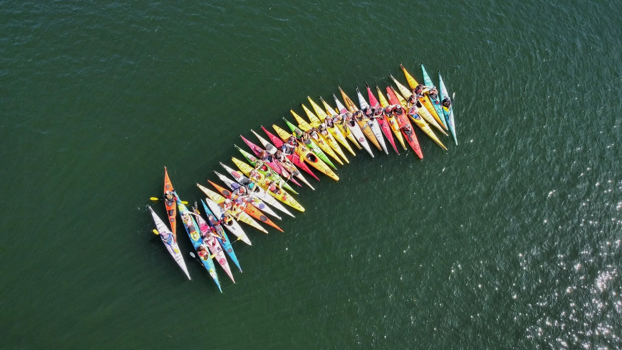 Group of kayakers making a line in the ocean