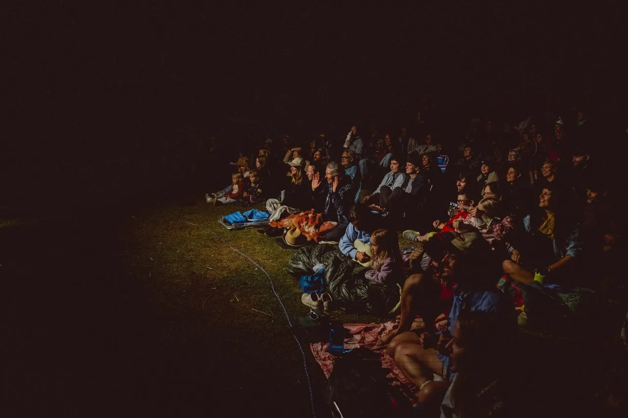 people gathered around an outdoor event at night