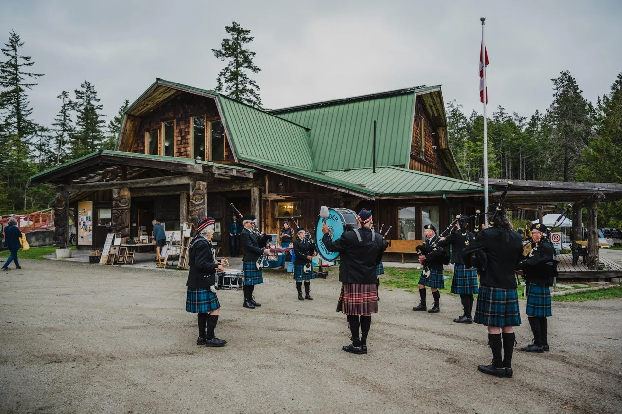 a group of people with bag pipes gathers outside a building